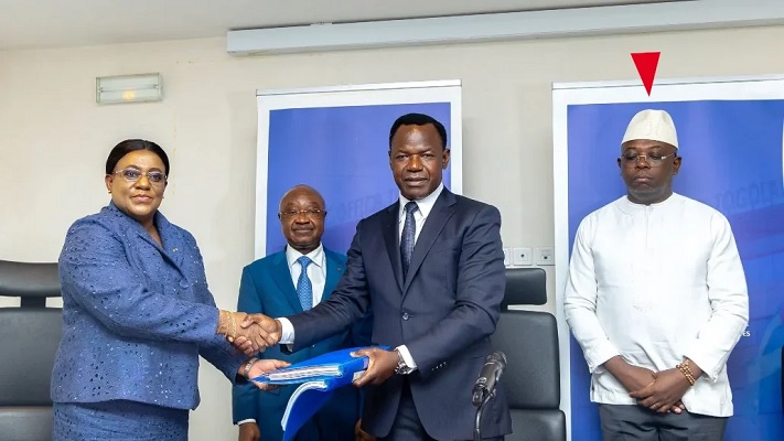 Passation de services entre Yawa Tsegan Barcola et Philippe Tchodie à l’OTR en présence du ministre des Finances Georges Essowè Barcola (à gauche en arrière plan) et le président du CA de l’OTR, Jonas Aklesso Daou (droite) | Photo: OTR